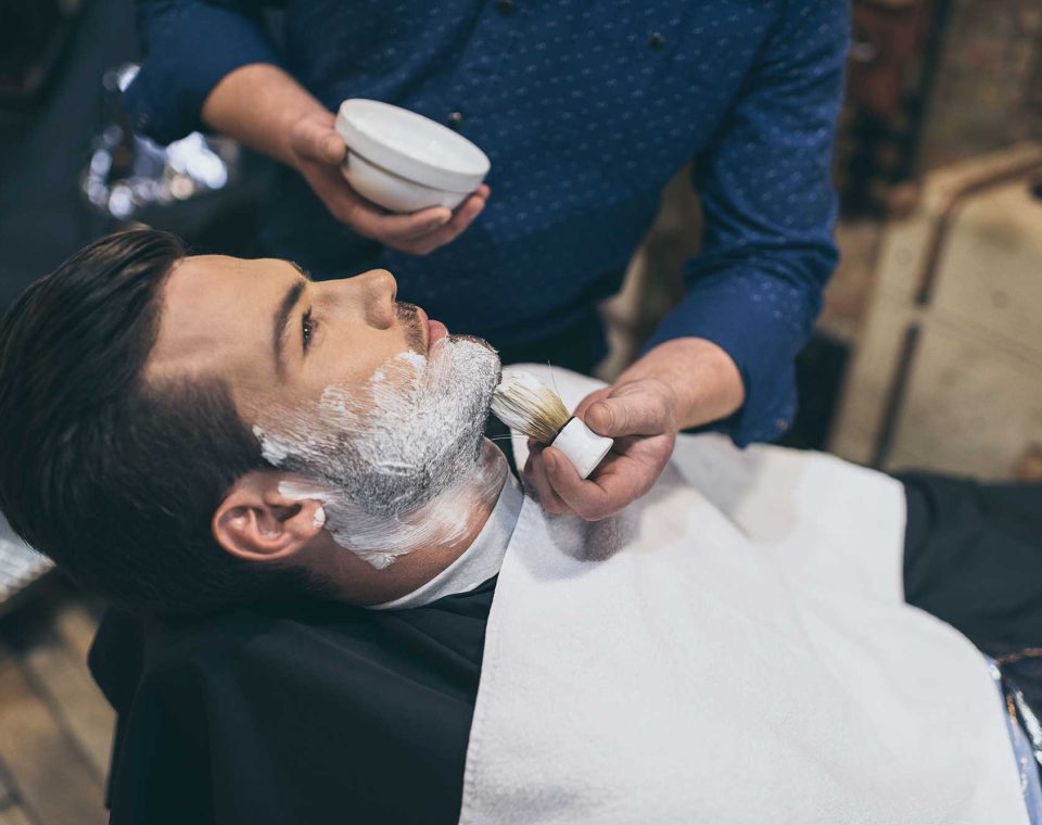 barber-applying-foam-before-shaving-of-customer-in-2022-12-16-17-03-17-utc.jpg