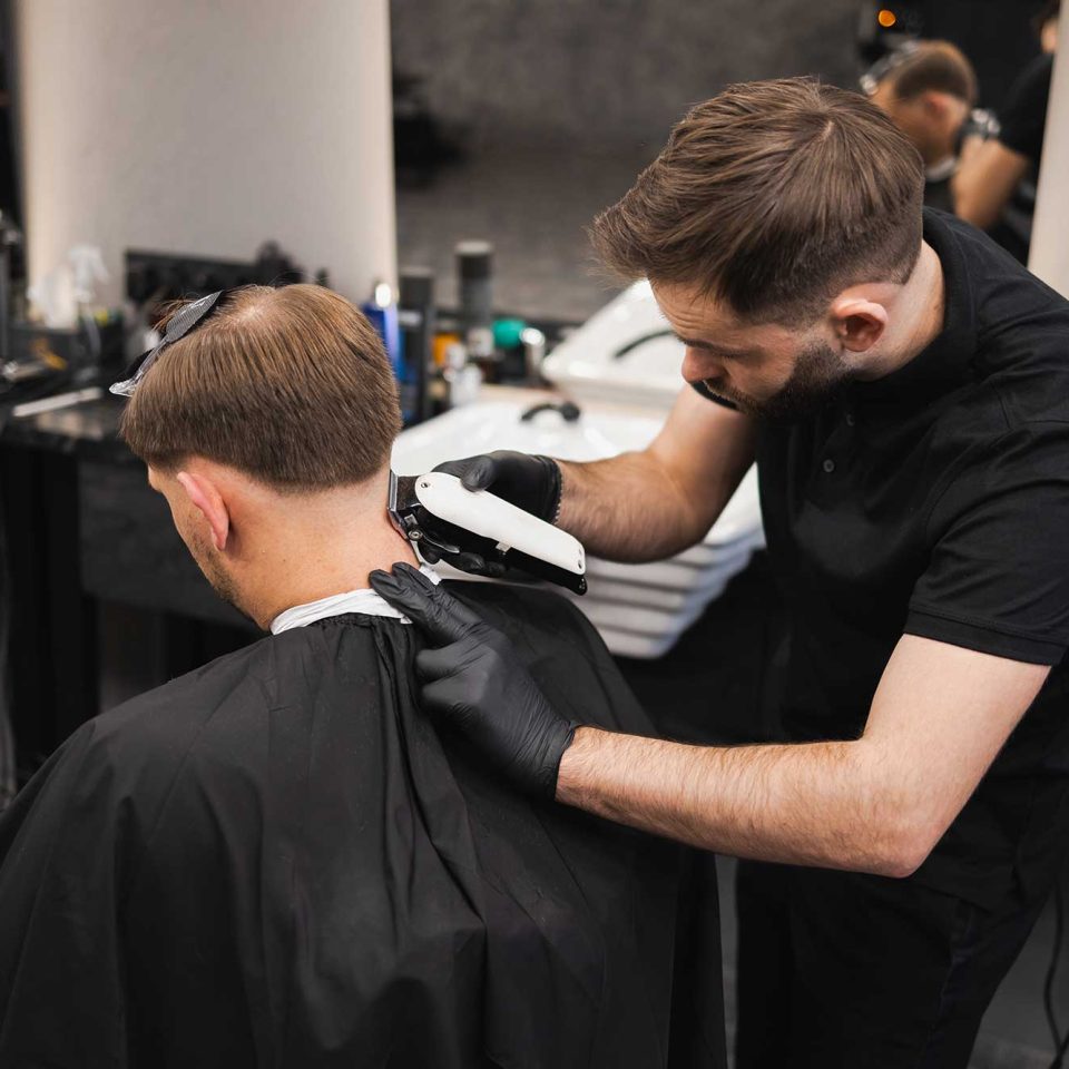 male-hairdresser-making-a-haircut-for-a-young-man-2022-02-17-20-02-40-utc.jpg